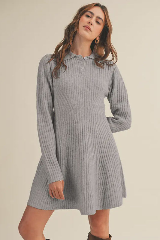 Woman wearing a gray ribbed dress against a beige background