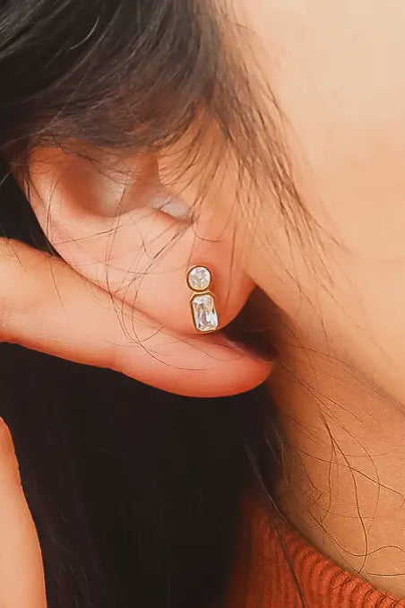 Close-up of an ear wearing a diamond earring with a blurred background