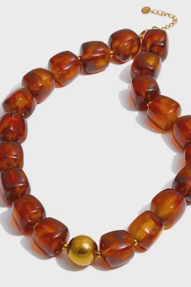 Brass beaded bracelet with a gold clasp on a white background