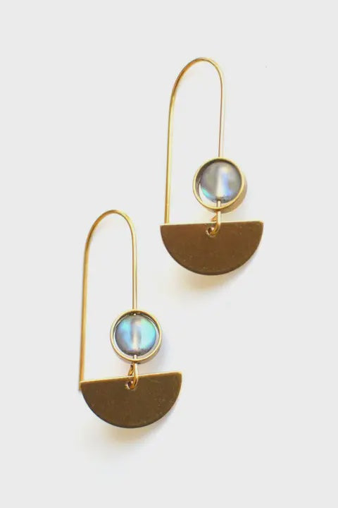 Pair of gold earrings with semi-circular designs and round gemstones on a light gray background