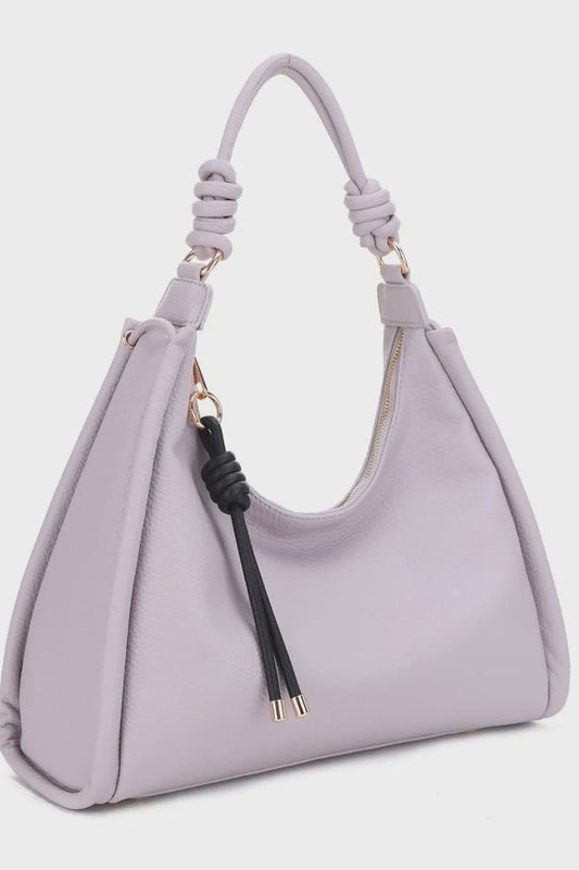 Lavender handbag with a decorative strap on a light gray background
