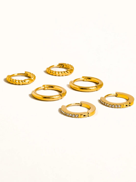 Set of gold hoop earrings on a white background