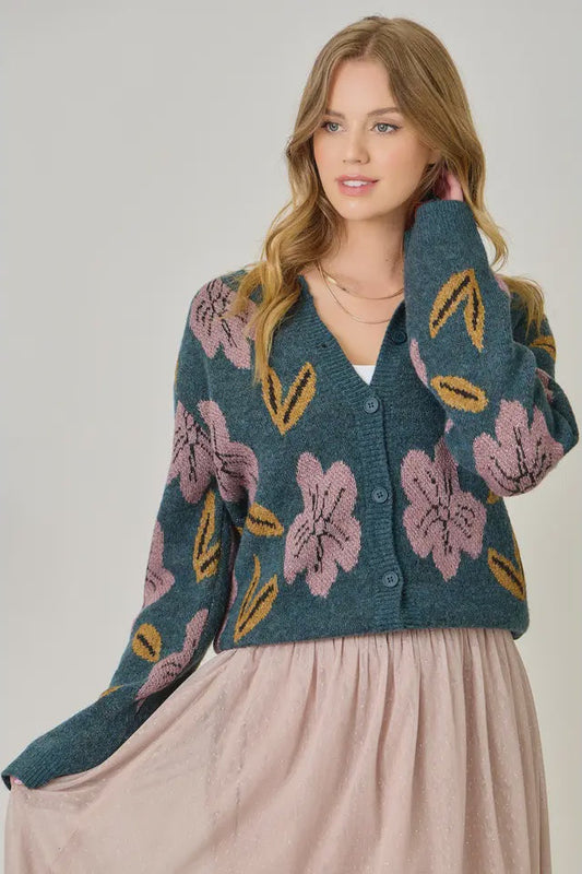 Woman wearing a floral patterned cardigan against a plain background