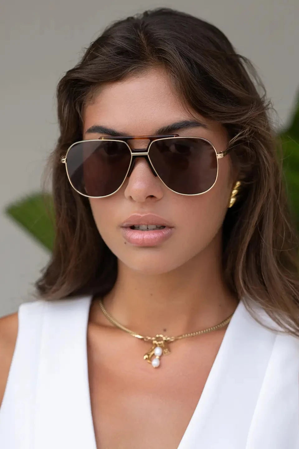 Woman wearing sunglasses with a neutral background