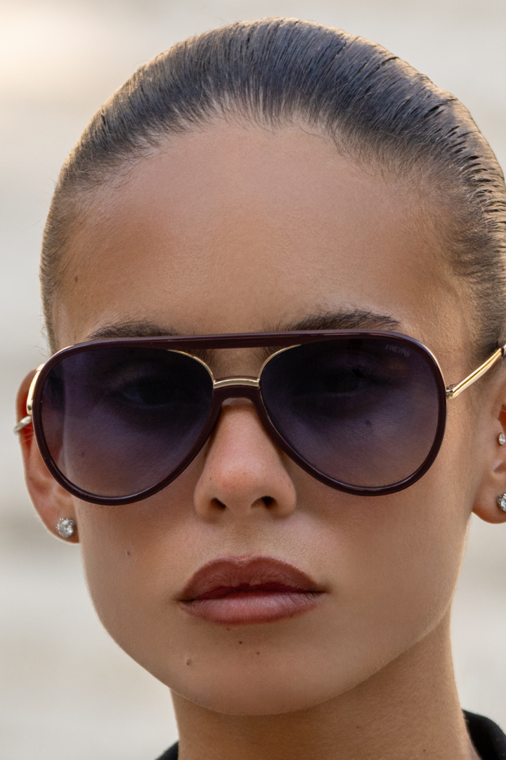Close-up of a person wearing sunglasses with a blurred background