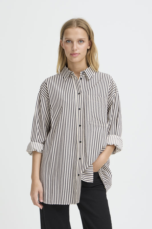 Woman wearing a black and white striped shirt on a plain background