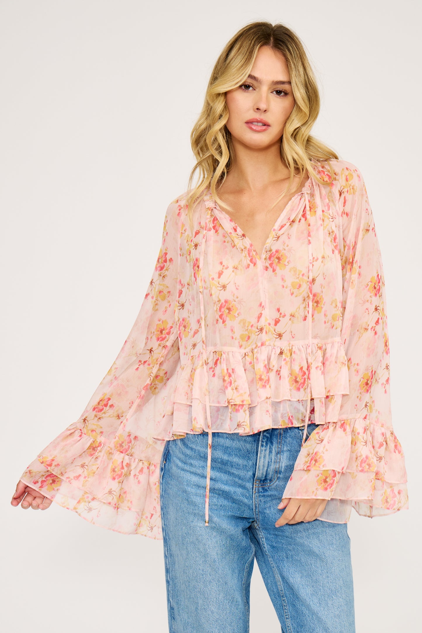 Woman wearing a floral blouse and jeans on a white background