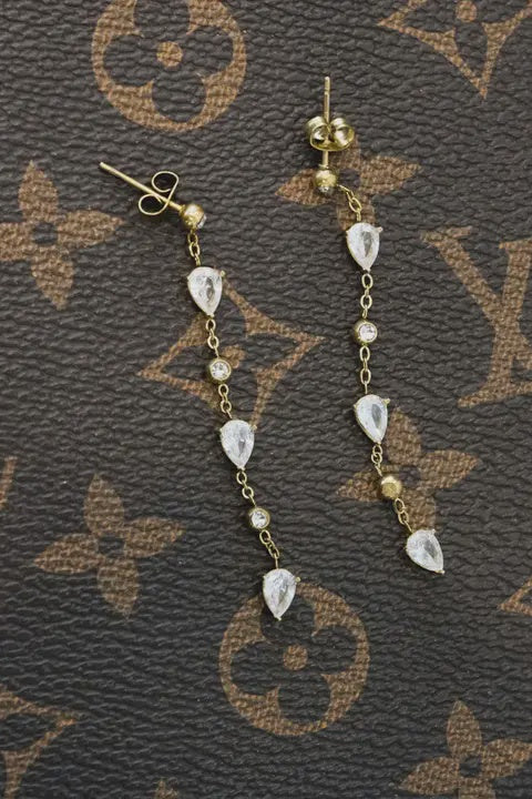 Gold and diamond earrings on a Louis Vuitton patterned surface