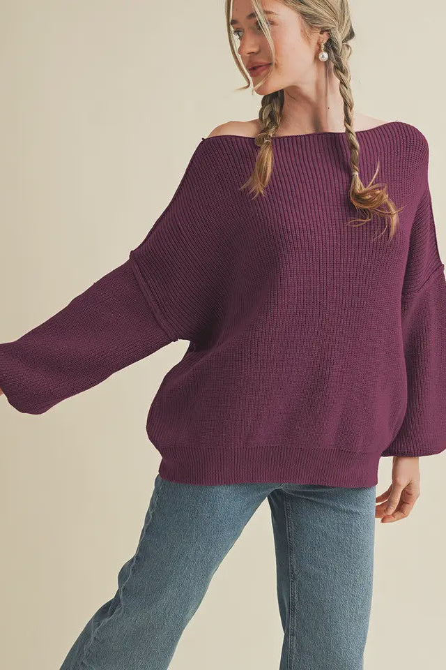 Woman wearing a purple sweater and blue jeans on a beige background