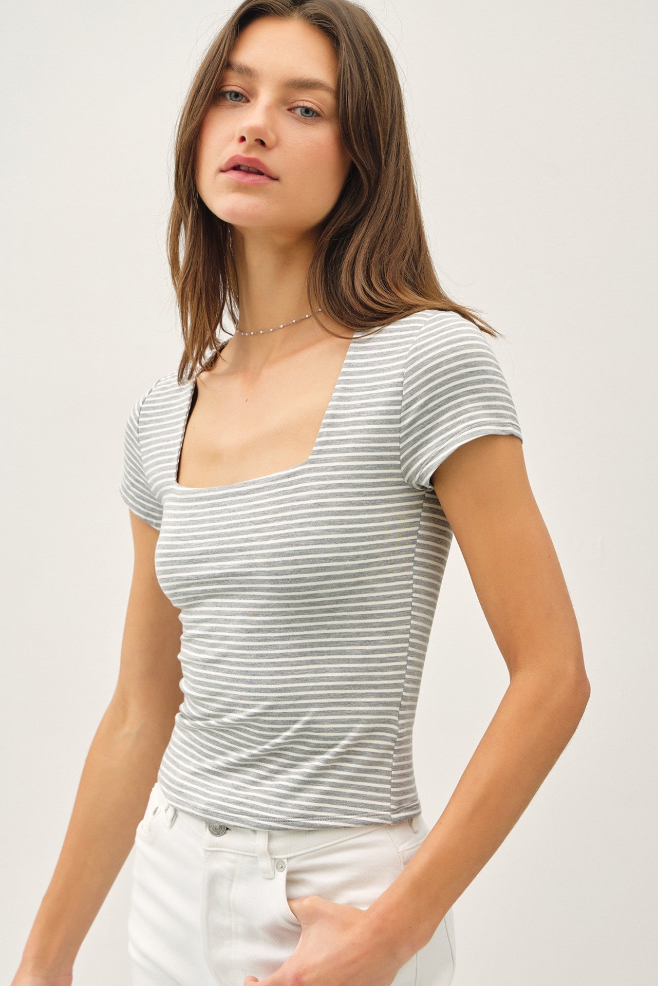 Woman wearing a striped short-sleeve top against a plain background