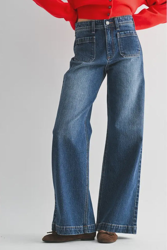 Blue jeans worn with a red top on a white background