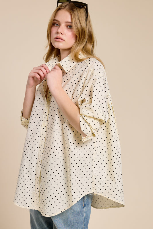 Woman wearing a polka dot blouse with a beige background