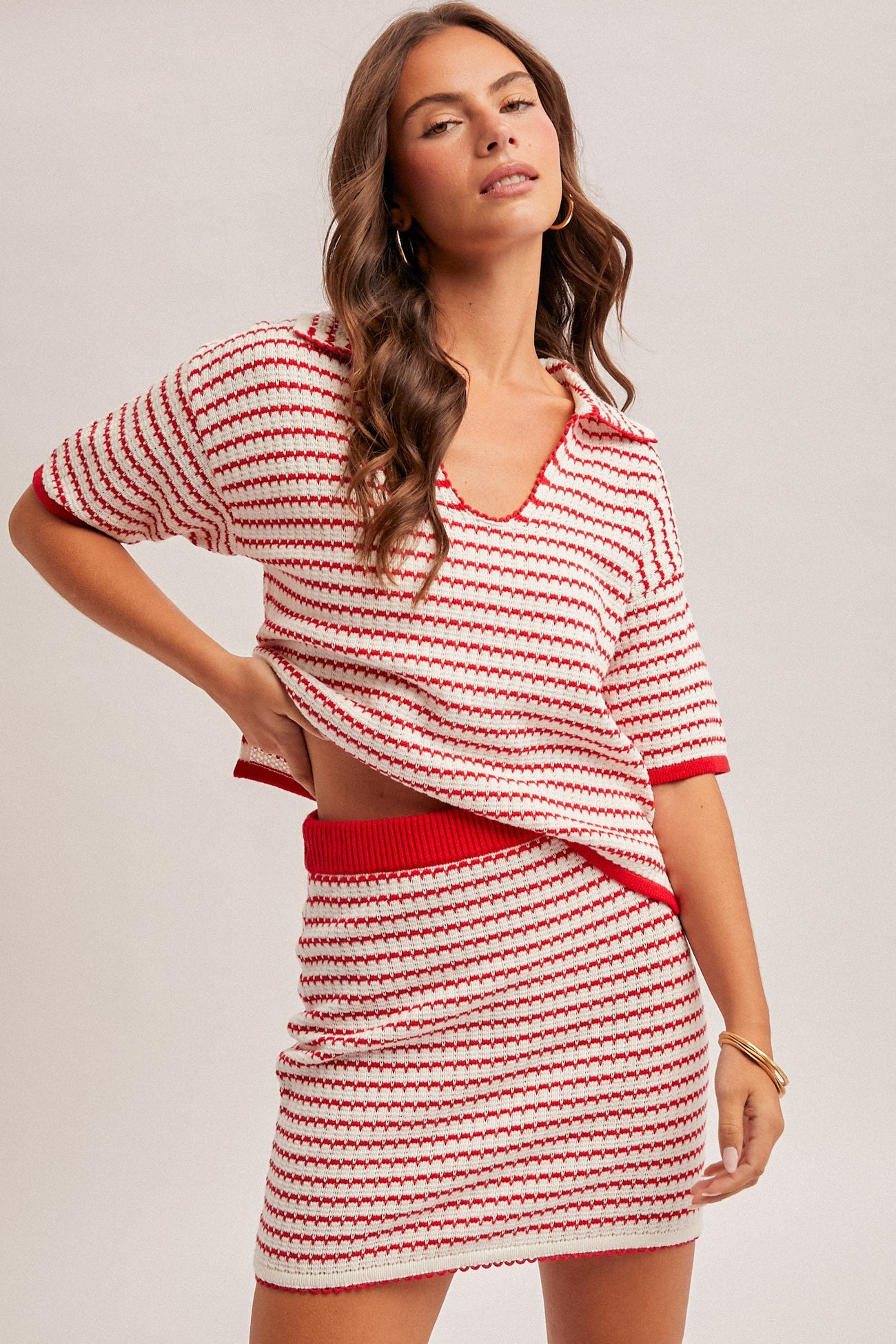 Woman wearing a red and white striped outfit on a plain background