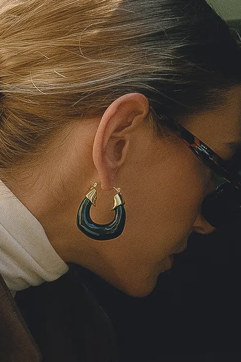 Close-up of a person wearing a hoop earring with a blurred background