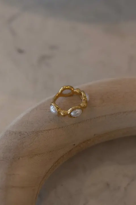 Gold ring with small stones on a wooden surface