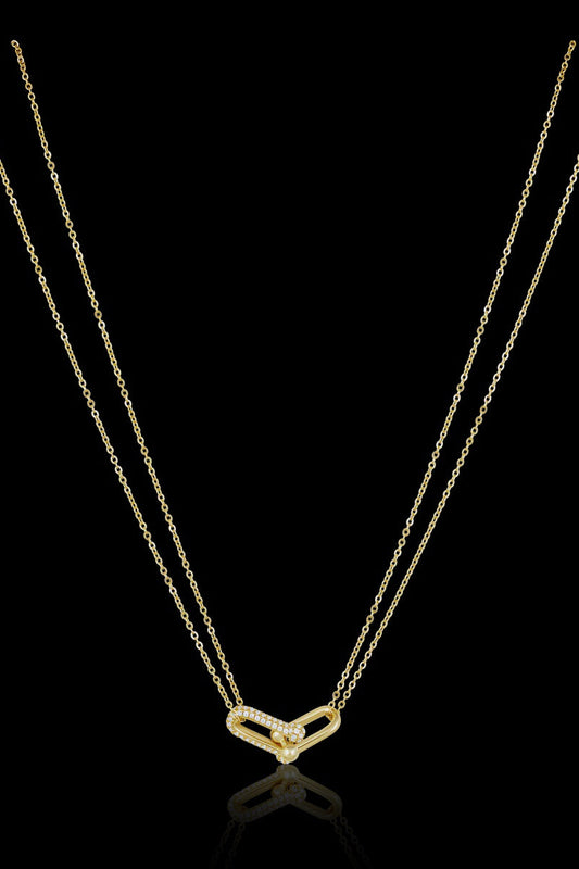 Gold necklace with a heart-shaped pendant on a black background
