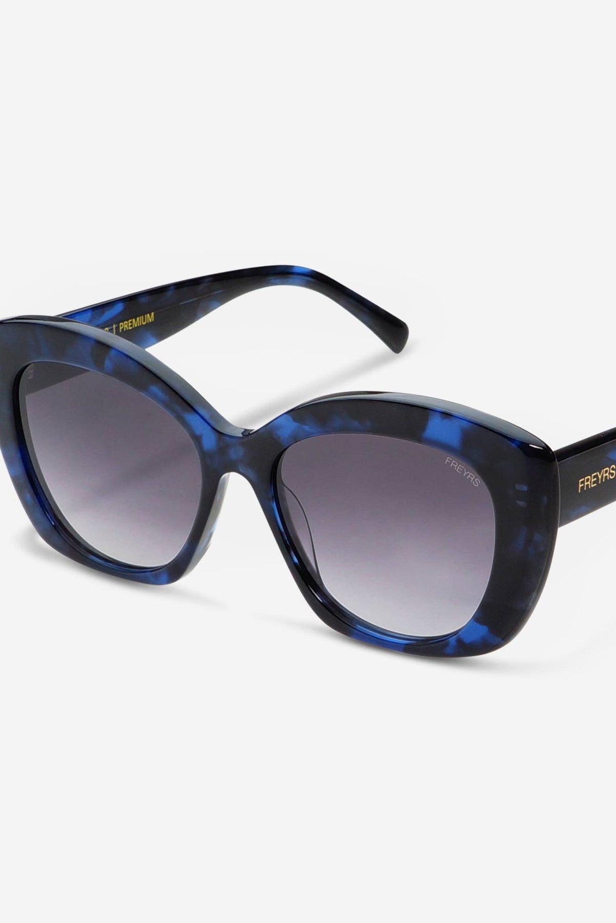 A pair of cat-eye sunglasses with a blue and black tortoiseshell patterned frame and gradient gray lenses, shown on a light gray background. The brand name 'PENIS' is visible in gold lettering on the temple arm.