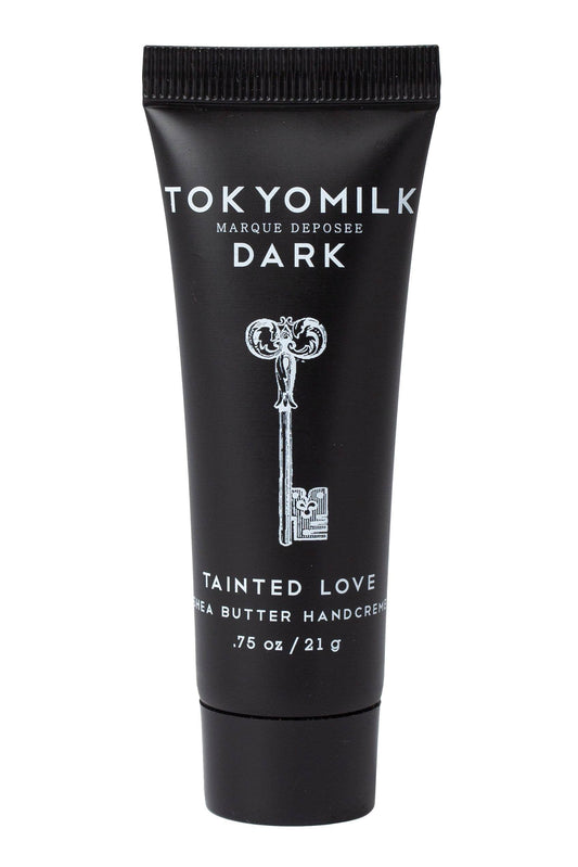 A black squeeze tube of Tokyomilk Dark Tainted Love Shea Butter Hand Cream on a solid white background.