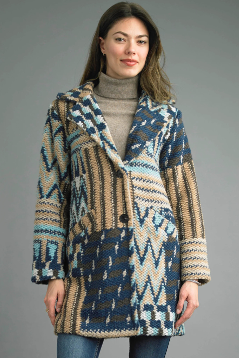 Woman wearing a patterned coat against a gray background