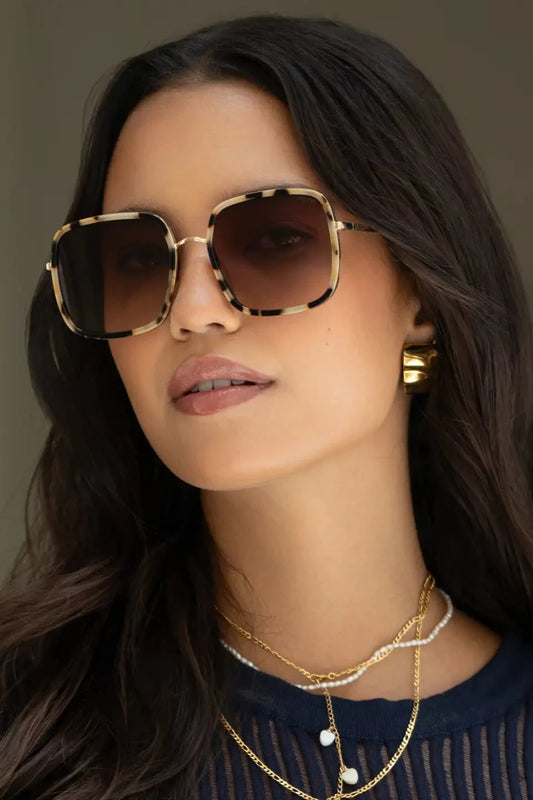 Woman wearing sunglasses with a neutral background
