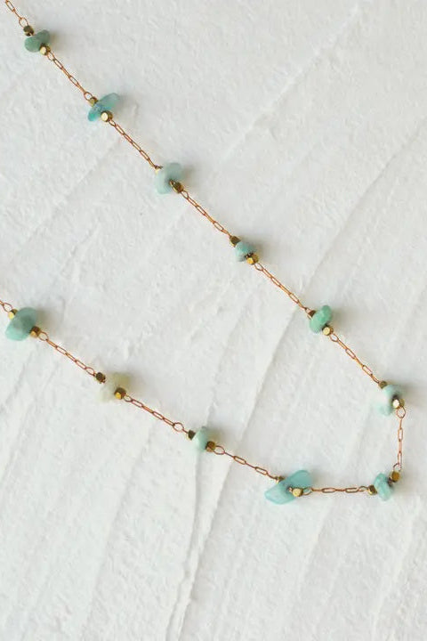 Necklace with turquoise beads on a white textured background