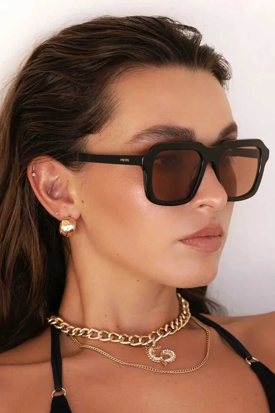 Woman wearing sunglasses with a plain background