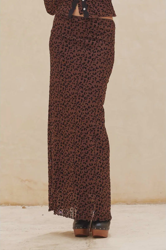 Brown patterned skirt worn by a person on a beige background