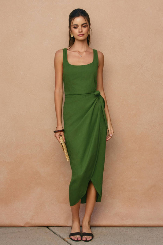 Woman wearing a green dress against a beige background