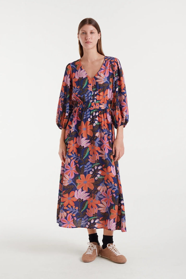 Woman wearing a colorful floral dress on a white background