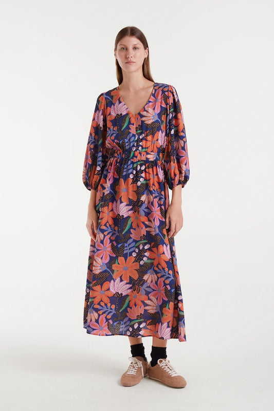 Woman wearing a colorful floral dress on a white background