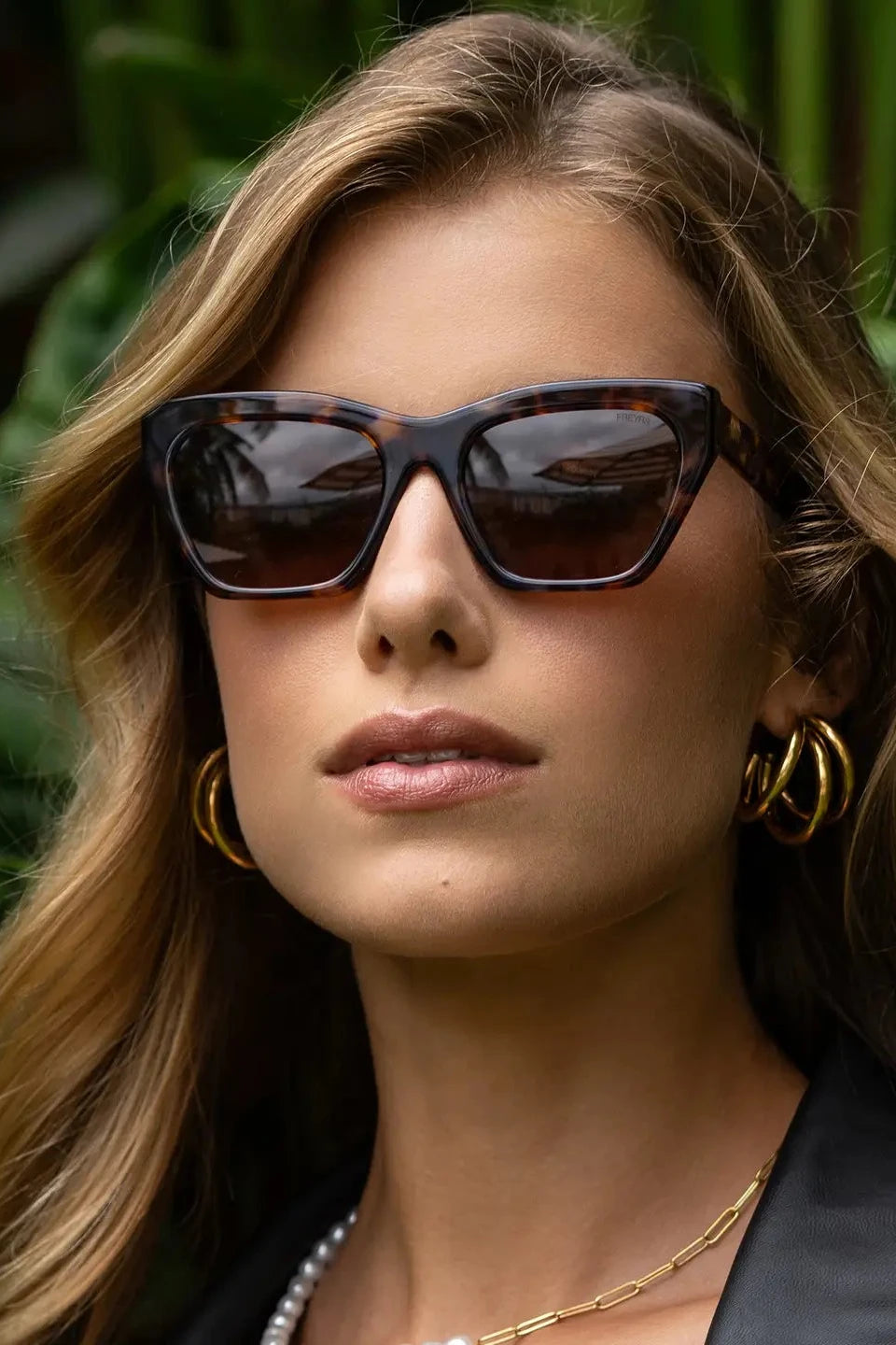 Woman wearing sunglasses with a blurred natural background
