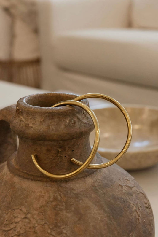Brown ceramic vase with gold accents on a blurred background