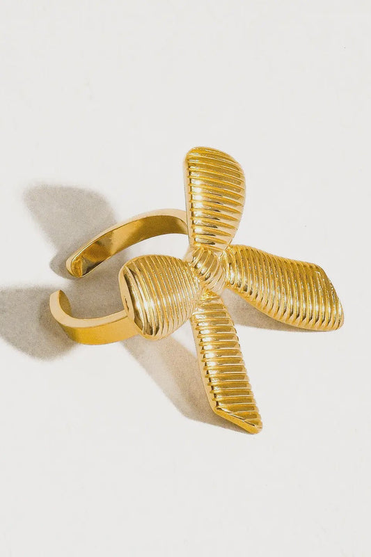 Gold bracelet with a unique design on a light gray background