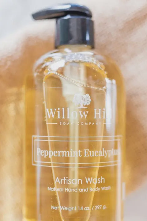 Bottle of Willow Hill Soap Company Peppermint Eucalyptus Artisan Wash on a textured beige background
