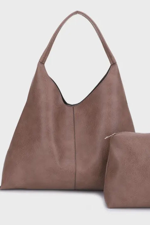 Brown leather handbag and matching pouch on a light gray background