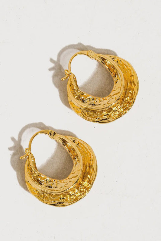 Pair of gold hoop earrings on a light gray background