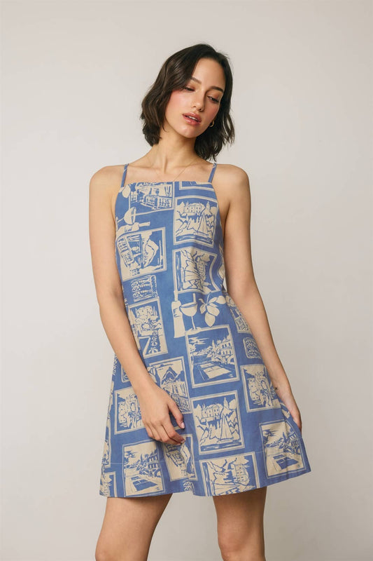 Woman wearing a blue patterned dress against a plain background