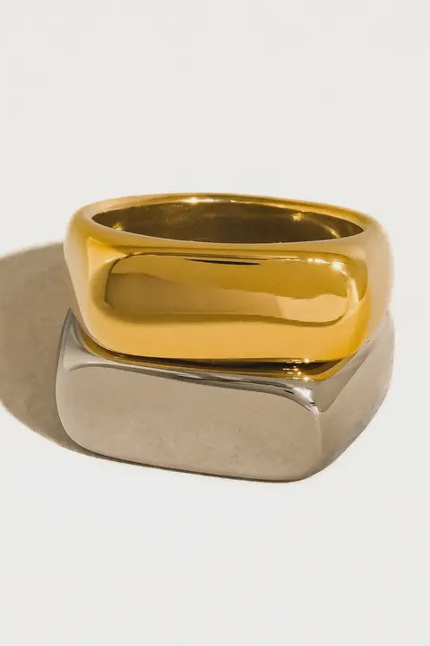 Gold and silver ring on a light gray background