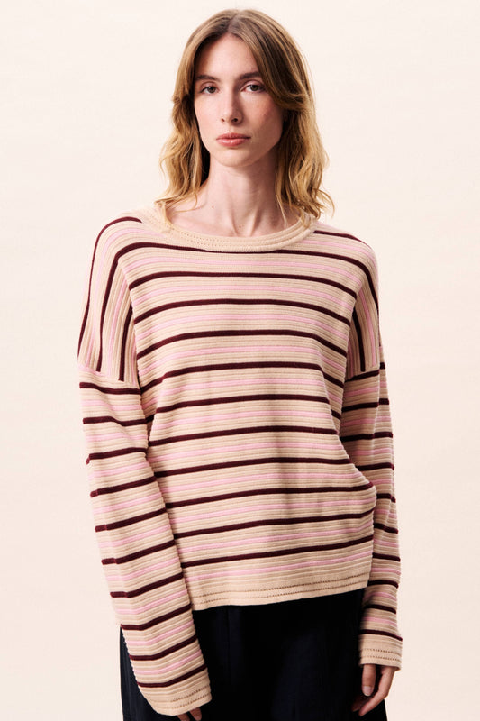 Woman wearing a striped sweater on a plain background