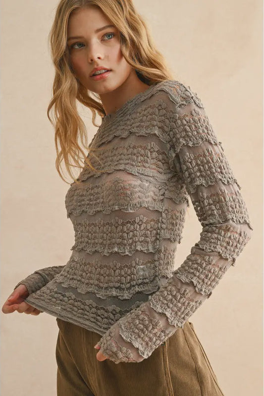 Woman wearing a textured gray sweater against a beige background