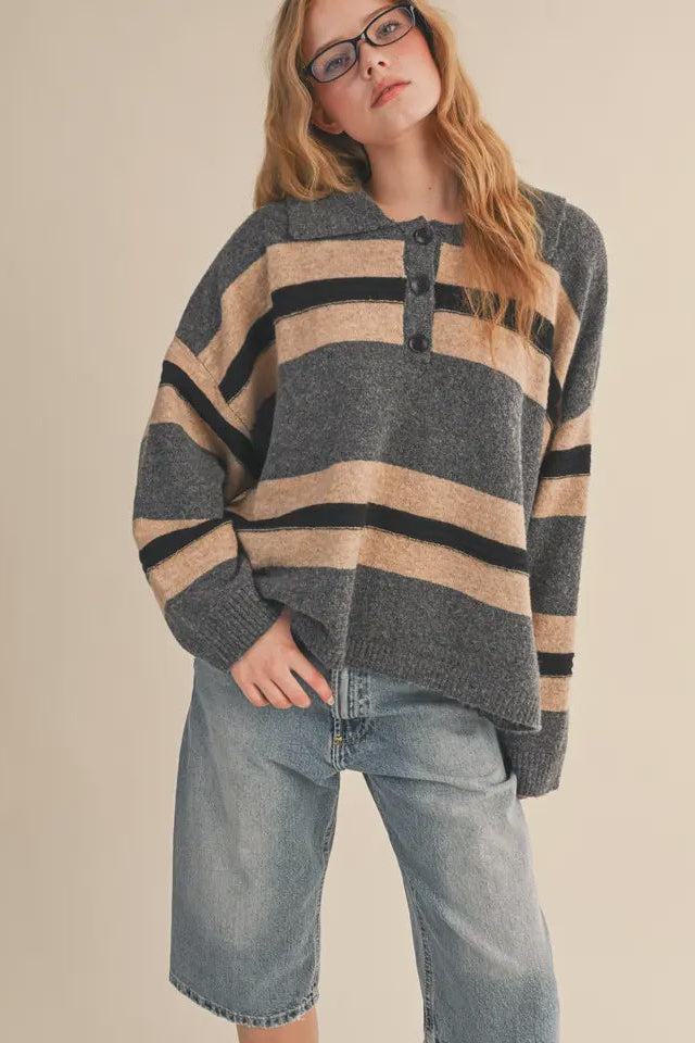 Person wearing a striped sweater and jeans on a beige background