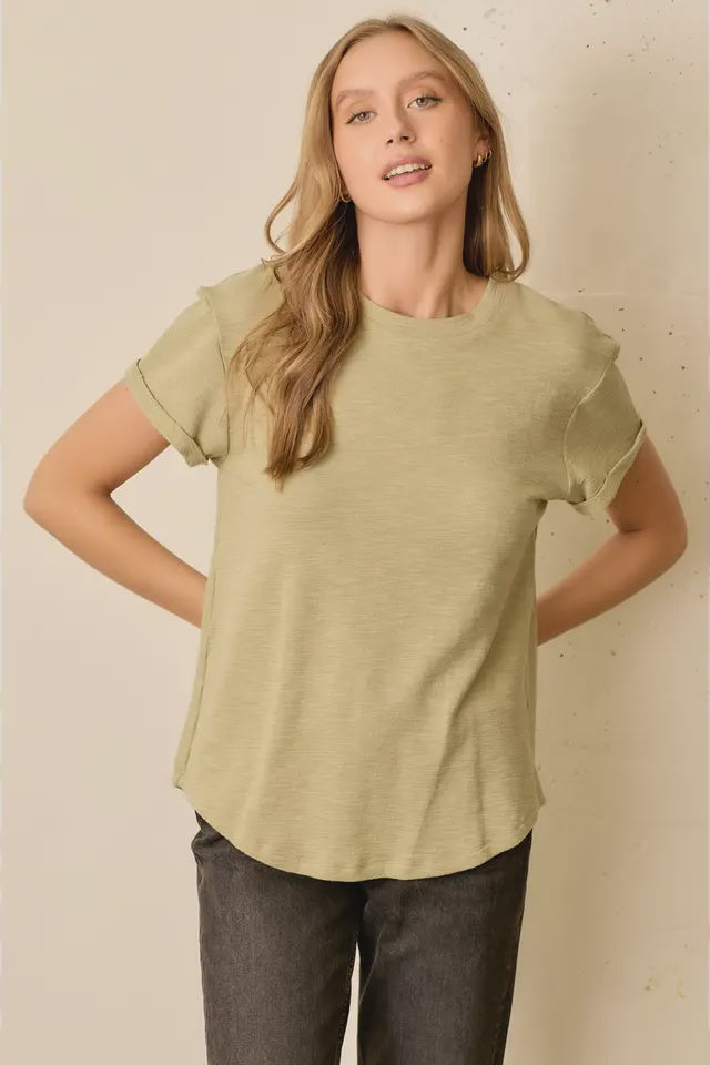 Woman wearing a light green t-shirt against a beige background
