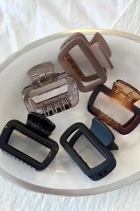 Set of hair clips on a white plate with a white background