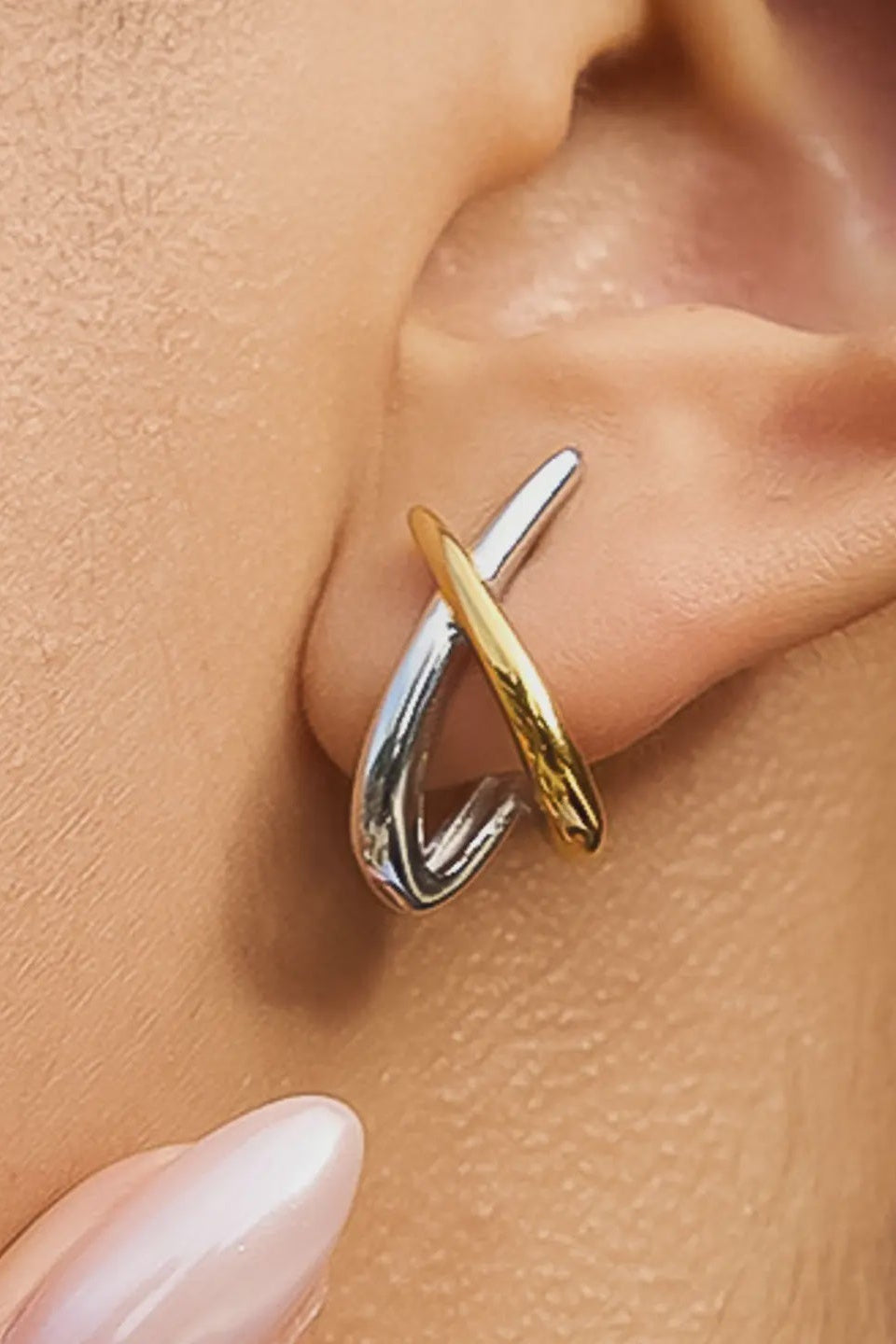 Gold and silver ear cuff on an ear with a blurred background
