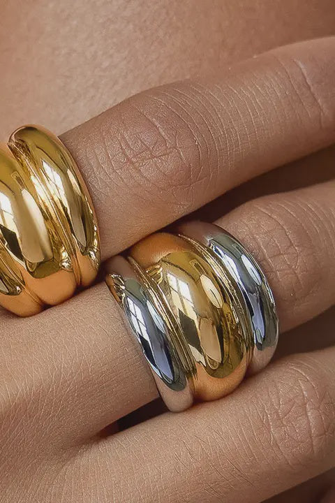Gold and silver rings on a person's finger