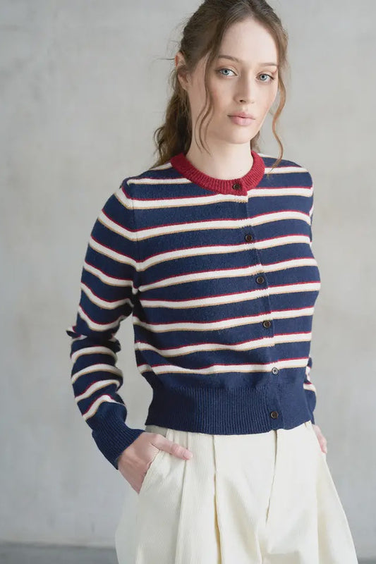 Woman wearing a striped sweater with a plain background