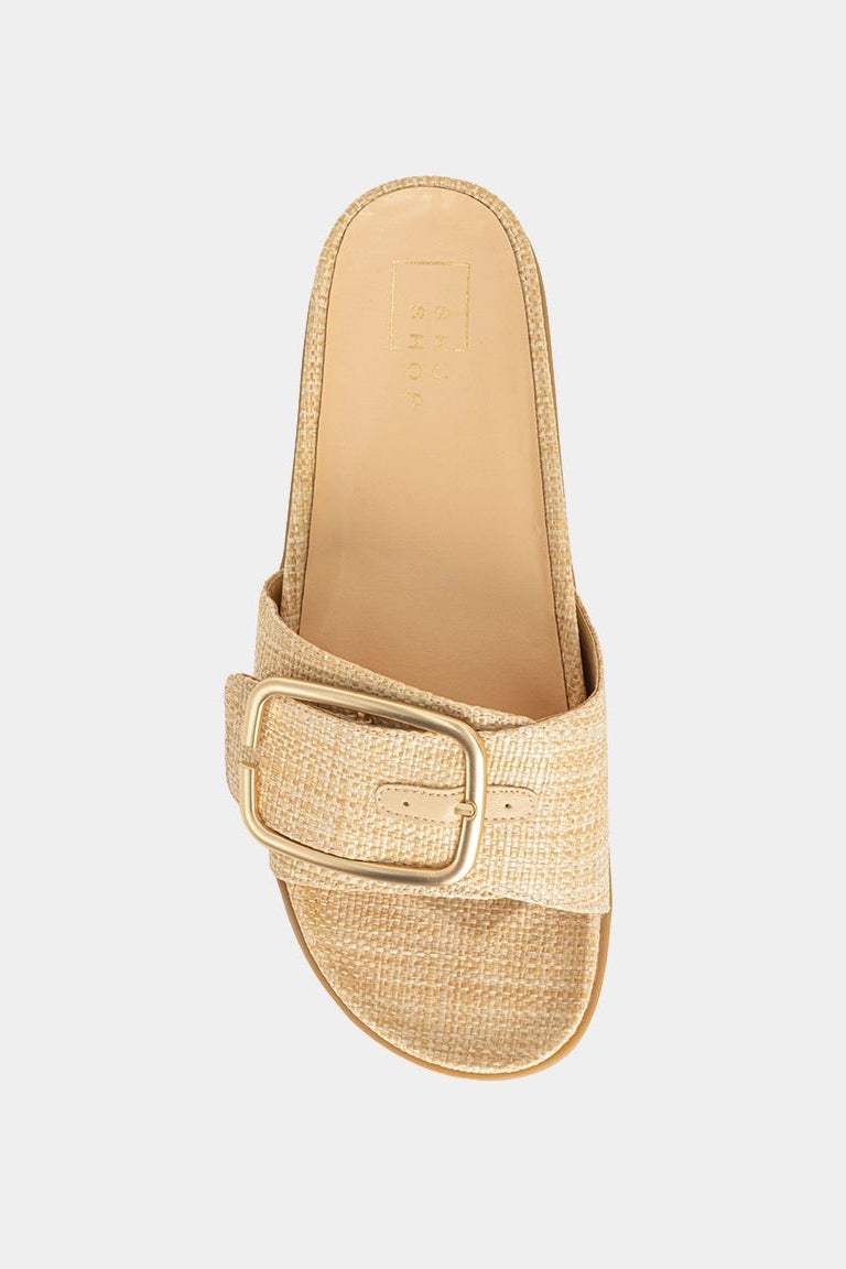Gold sandal with a buckle on a light gray background