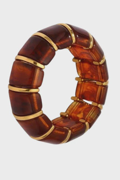 Brown bracelet with gold accents on a light gray background