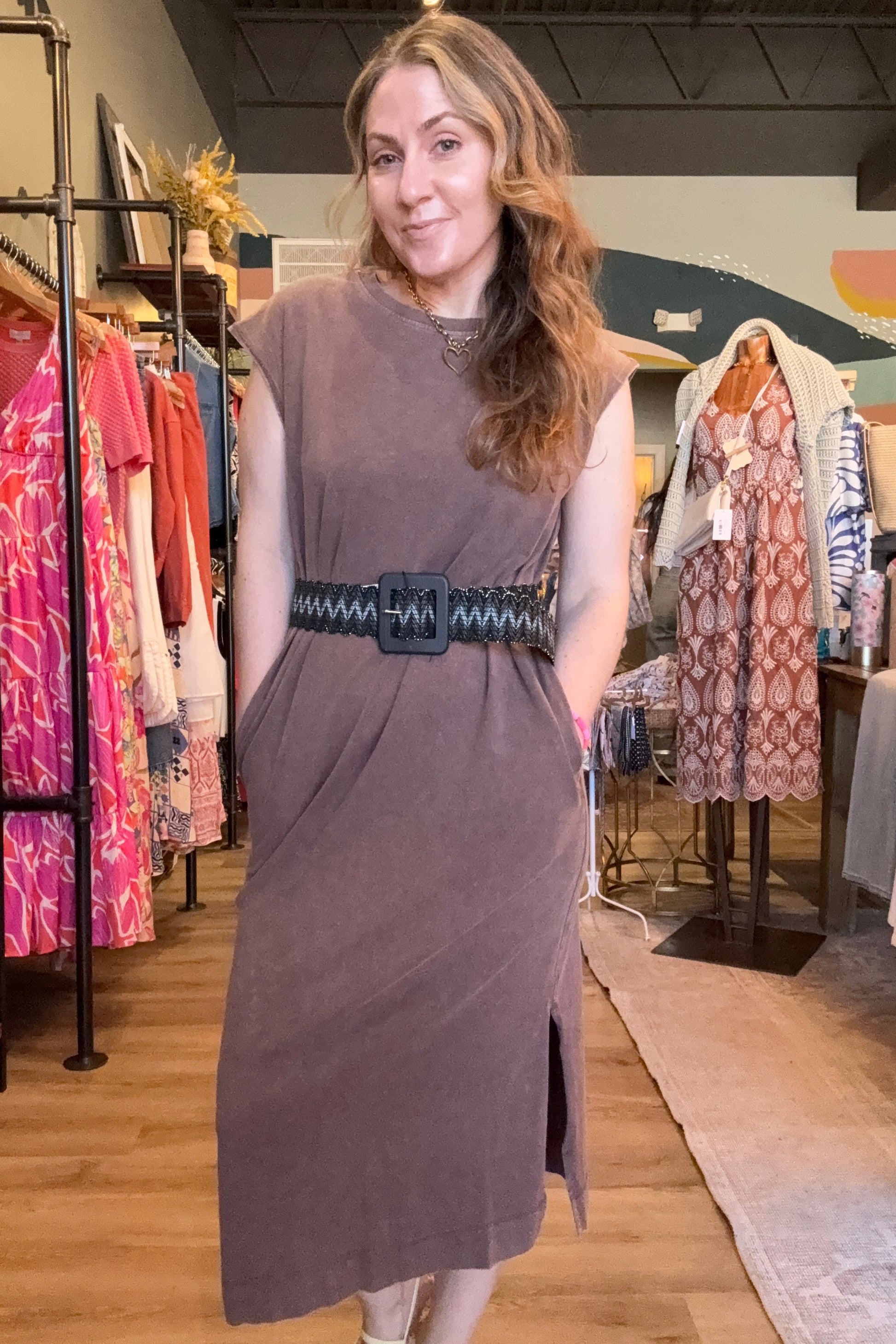 Woman wearing a sleeveless dress with a belt in a store setting