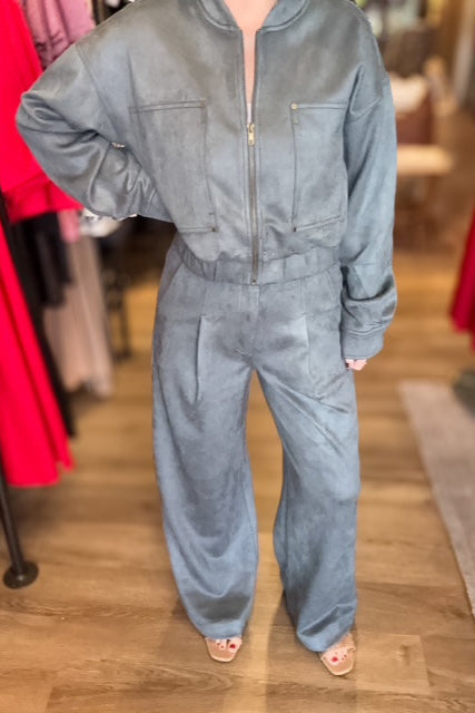 Person wearing a gray jumpsuit in a clothing store setting